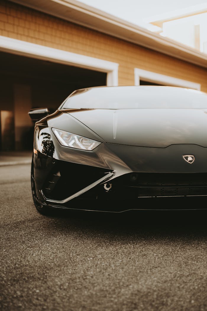 Close-up of a black Lamborghini sports car with a focus on headlights and emblem.